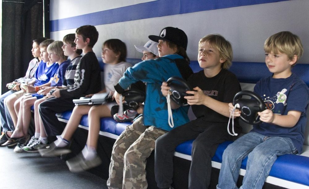 Children playing video games together at home