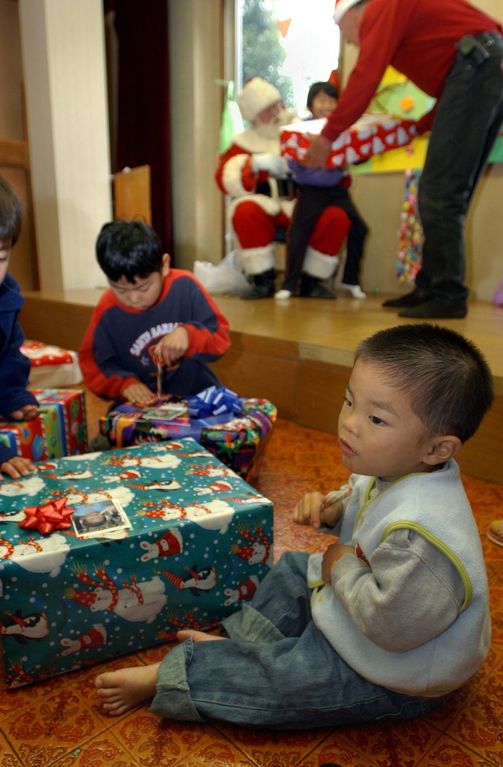 Child opening a wrapped Christmas present