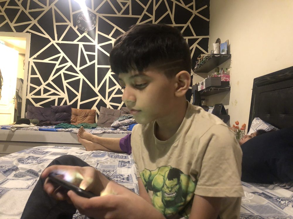 A boy playing a video game on a computer at home