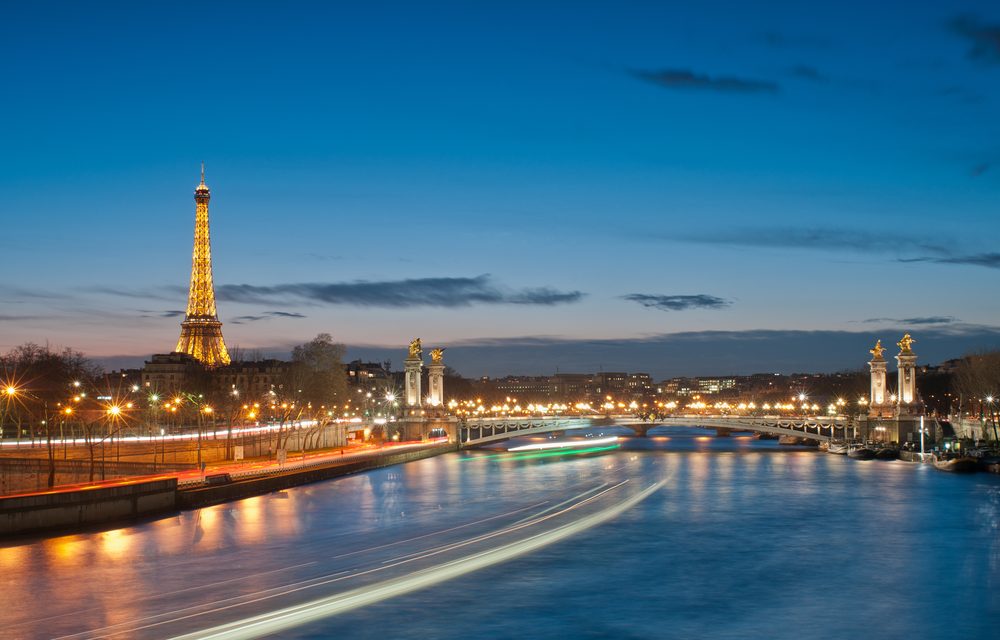 The Eiffel Tower and Pont Alexandre III in Paris lit up at night