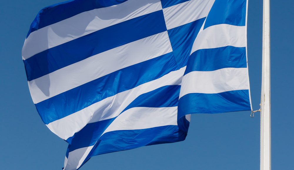 Greek flag flying above the Acropolis in Athens