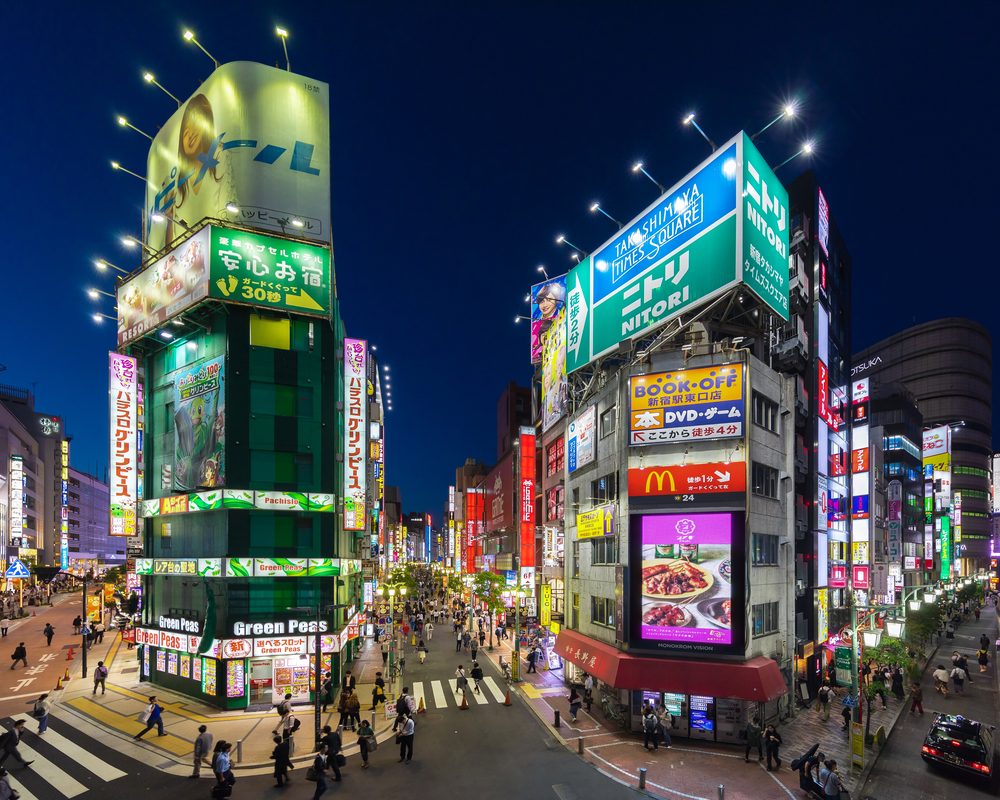 Illuminated street signs with Japanese text at night in Shinjuku, Tokyo