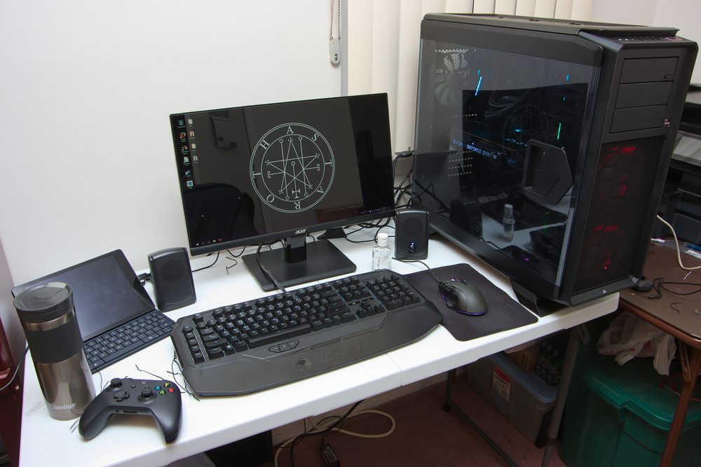 A PC gaming desk setup with a monitor, keyboard and mouse, representing PC gaming as a platform for language learning
