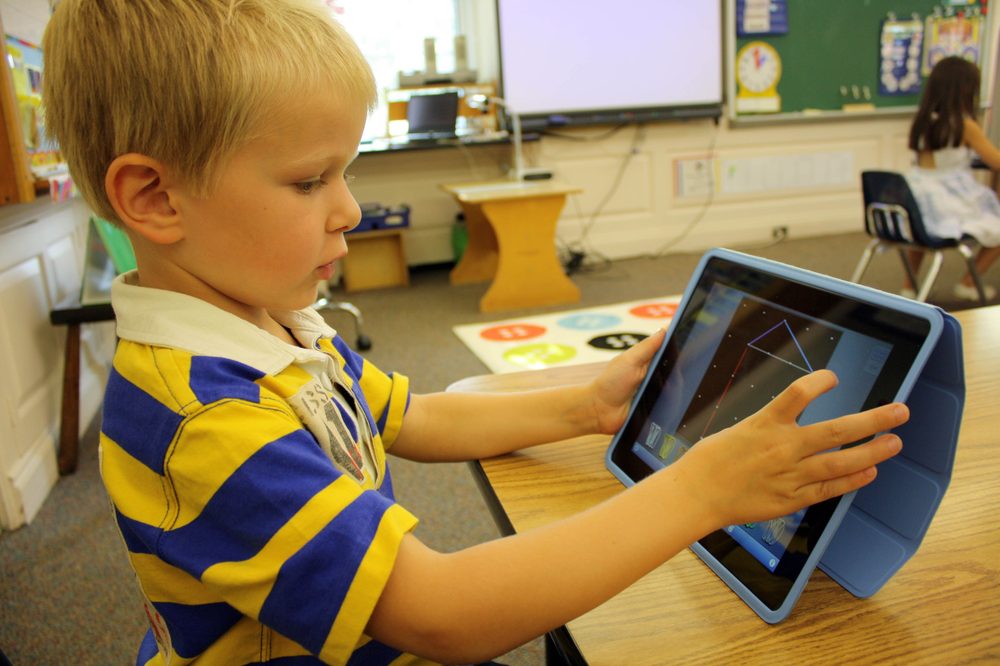 Young child using a tablet computer at a table