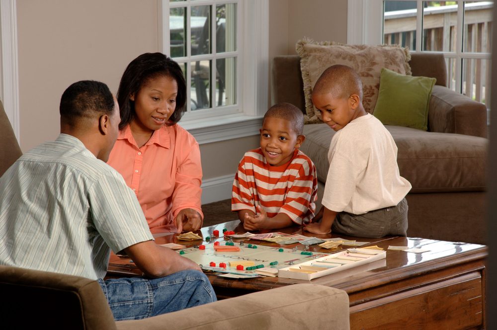 Family sitting around a table playing a game together