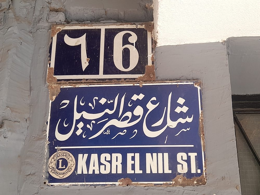 Street sign for Qasr el-Nil Street written in Arabic and English in Cairo, Egypt