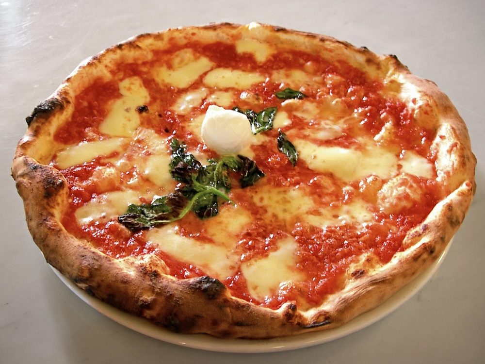 Neapolitan pizza margherita on a plate in a pizzeria in Naples, Italy