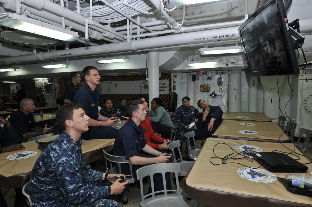 A group playing video games together on a shared screen with controllers