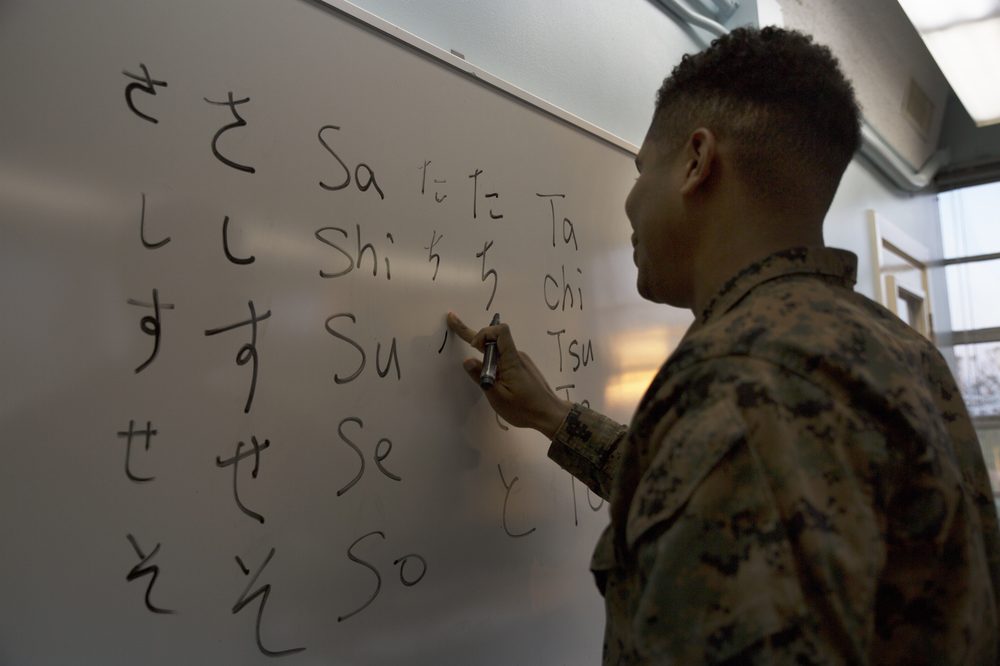 A language class writing hiragana characters on a whiteboard