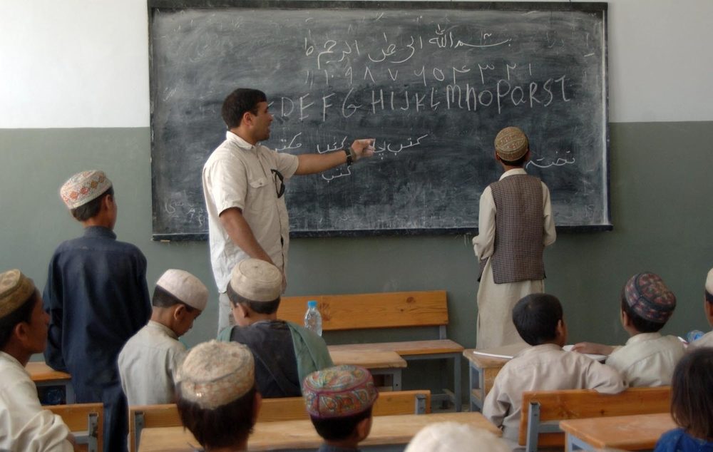 Students practising English together at a classroom blackboard
