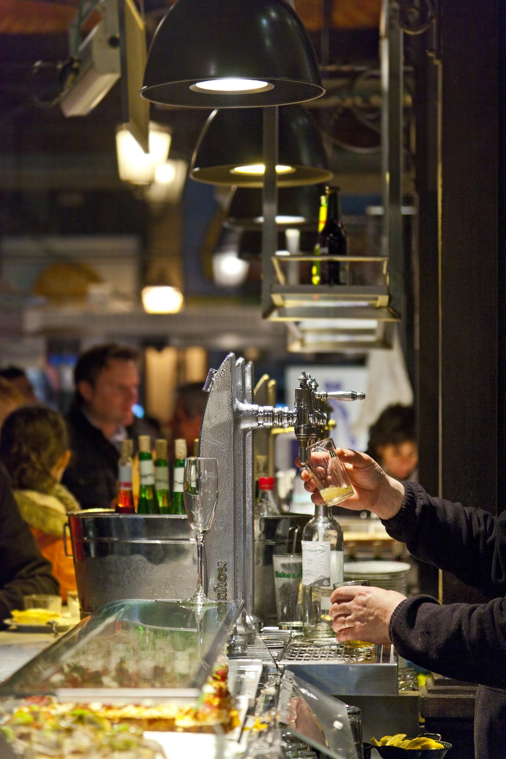 Bustling indoor food market in Madrid, Spain, with vendor stalls and shoppers