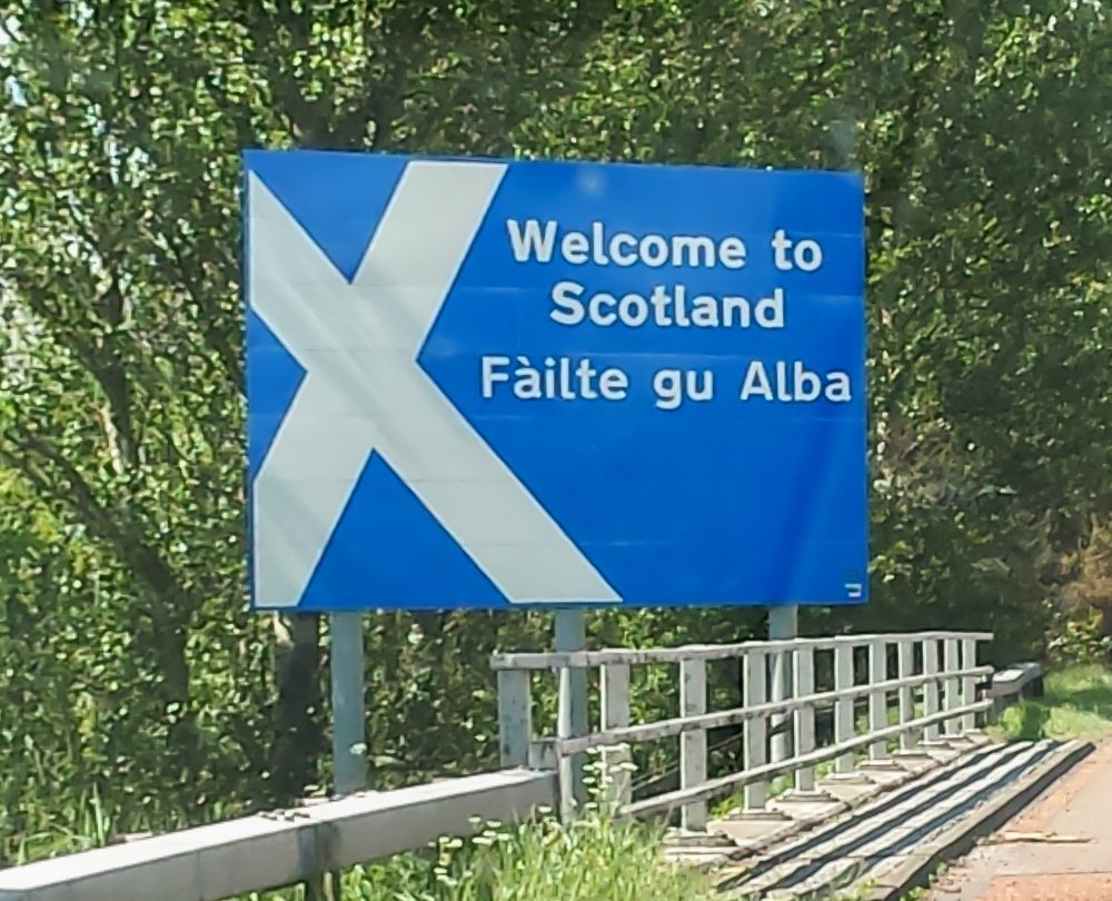 Bilingual welcome sign at the border between England and Scotland, in English and Gaelic