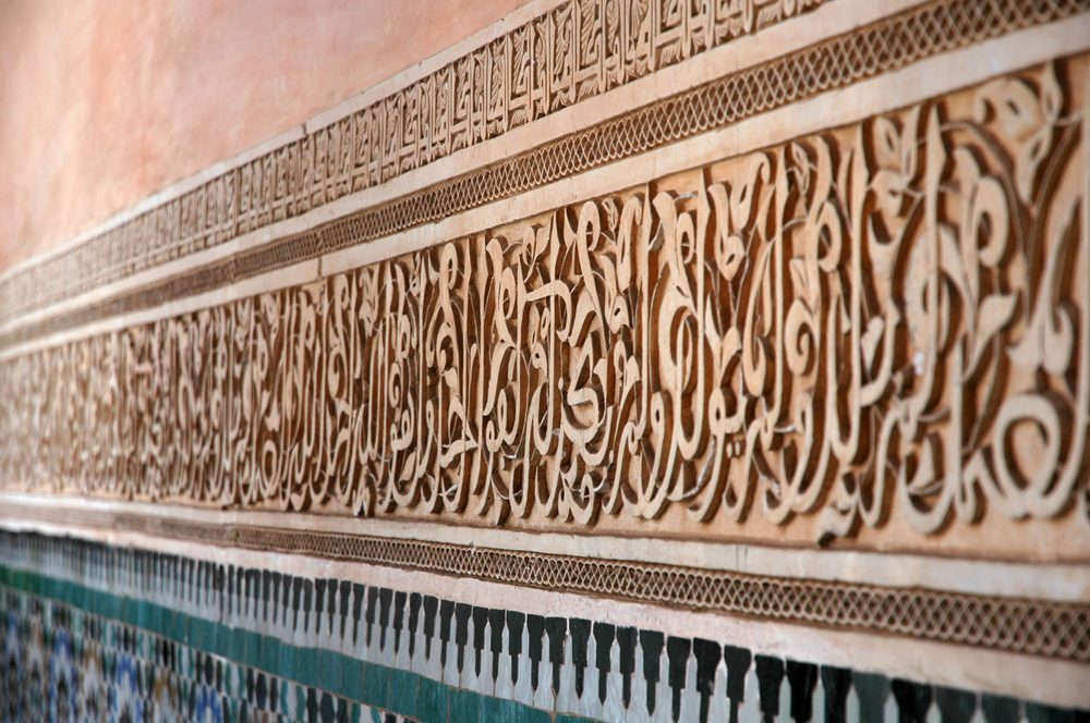 Sculpted Arabic calligraphy on the walls of the Ben Youssef Madrasa in Marrakech