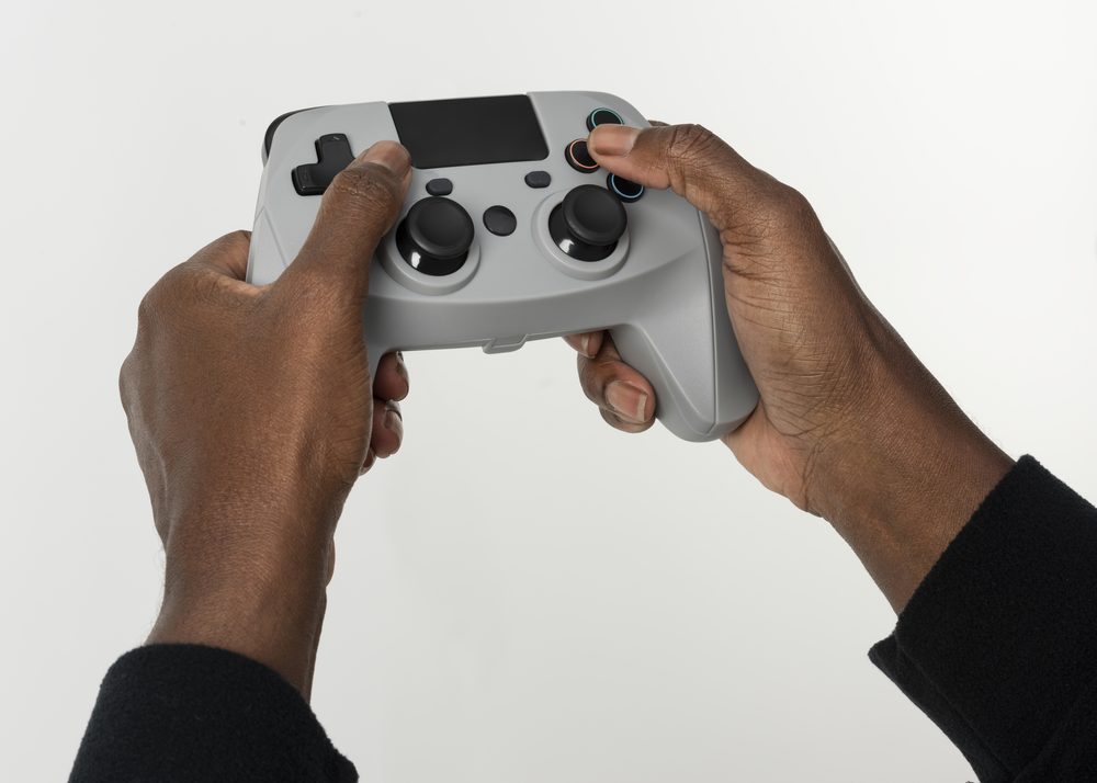 Hands holding a video game controller, representing gamers who quit Duolingo for something more engaging
