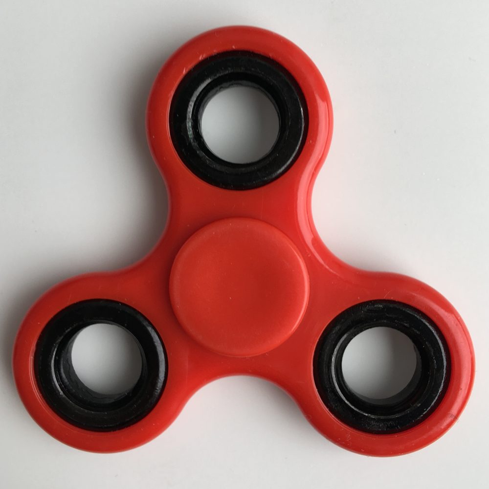 A red fidget spinner, an object often associated with ADHD and restlessness
