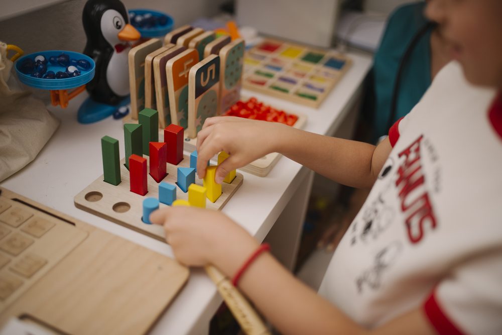 Child playing with colourful building blocks, representing how naming objects builds early vocabulary